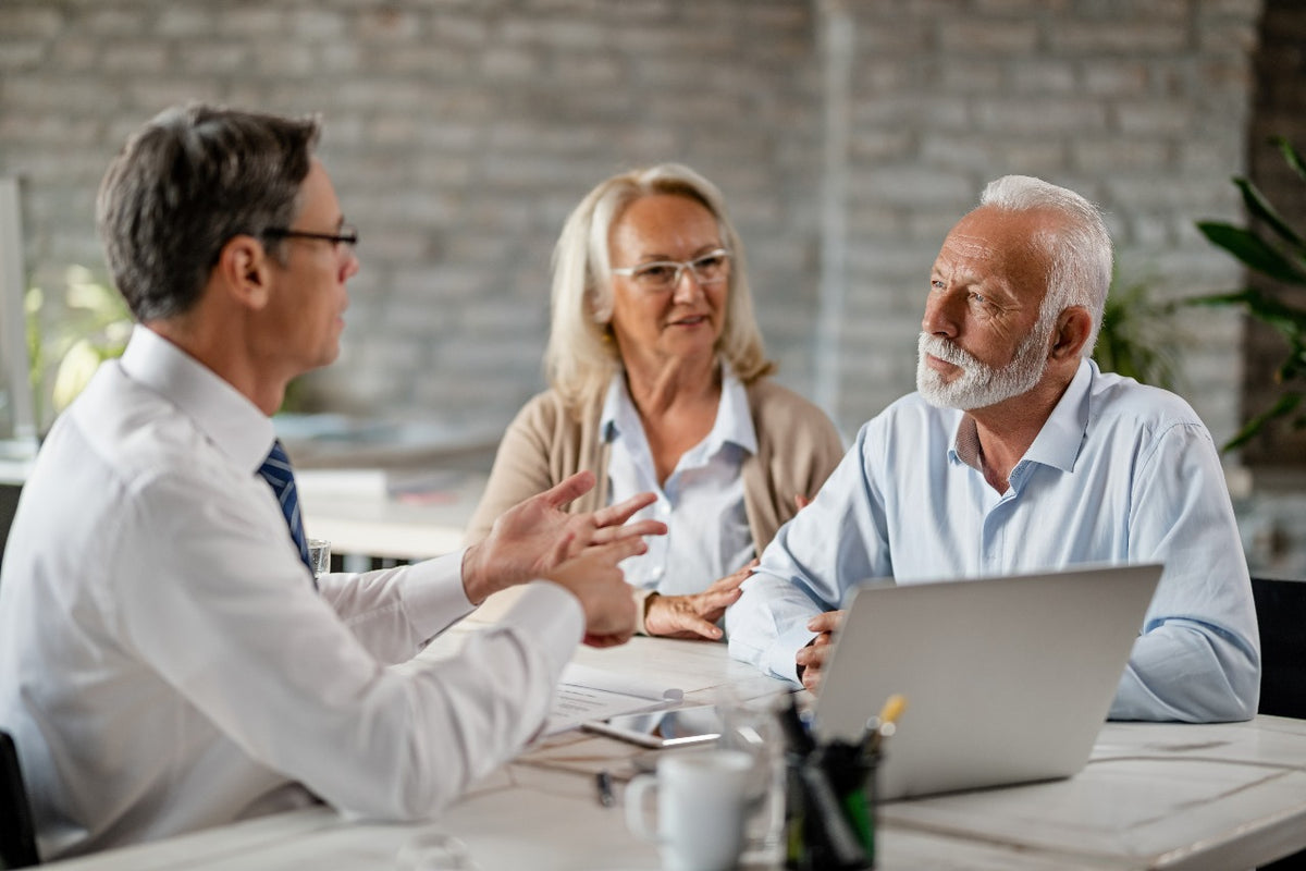 A professional life insurance advisor meeting with a senior couple to discuss life settlement options, providing trusted financial guidance on selling a life insurance policy for cash through Lifestone Settlements.